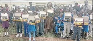  ?? (File pic) ?? Minister Savannah Maziya (C) with pupils from different schools under the Hlane community, after donating 1 500 pairs of shoes to them.