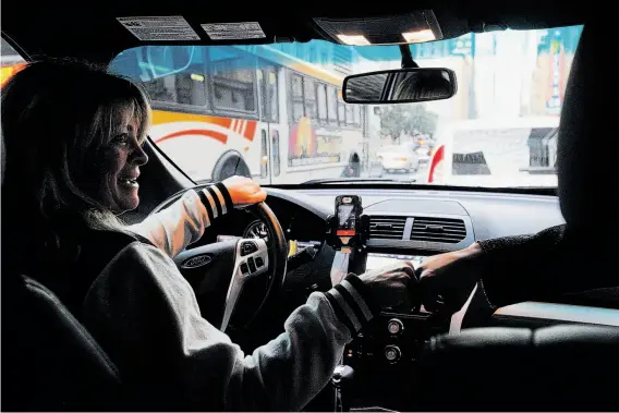  ?? Leah Millis / The Chronicle ?? Erin Kennedy, who drives partly to put her three sons through college, fist bumps passenger Stella Inciarte while picking her up near Mission Street in S.F.