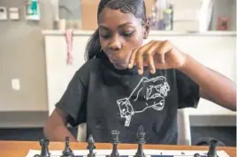  ??  ?? ReaAsia Hollins, 15, contemplat­es a move during a Make A Chess Move tournament this week that drew a dozen 11- to 24-year-old players.