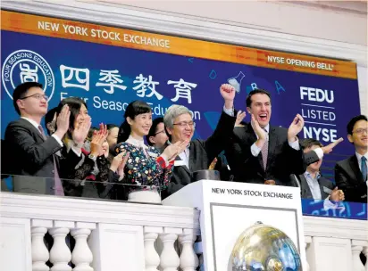  ?? (Brendan McDermid/Reuters) ?? FOUR SEASONS EDUCATION chairman and CEO Peiqing Tian rings the opening bell in celebratio­n of his company’s IPO at the New York Stock Exchange yesterday.