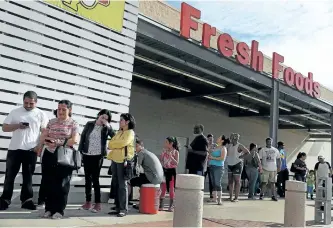  ?? JOE RAEDLE/GETTY IMAGES ?? People wait in line in hopes of buying water at a grocery store after the water supply to the city of Beaumont, Texas, was shut down after Harvey passed through on Friday.