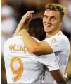  ?? CURTIS COMPTON/CCOMPTON@AJC.COM ?? Atlanta United’s Julian Gressel (right), hugging Romario Williams after a goal in June, filled in as a holding midfielder Saturday.