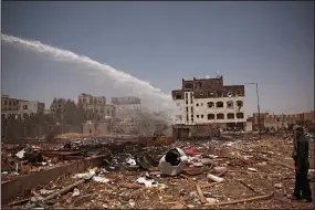  ?? (AP/Hani Mohammed) ?? Firefighte­rs extinguish a blaze after Saudi-led airstrikes Saturday in Sanaa, Yemen.