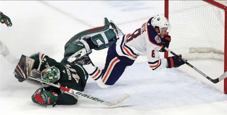  ?? Jim moNe/The associaTeD Press ?? Edmonton Oilers forward Ty Rattie, being tripped up by Minnesota Wild goalie Devan Dubnyk, deserves a shot at more top-line ice time, Jim Matheson says.