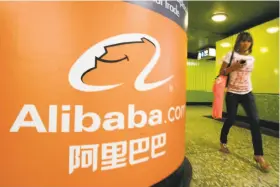  ?? Mike Clarke / AFP / Getty Images 2007 ?? A pedestrian walks past Alibaba.com advertisin­g in Hong Kong. The company’s stock struggles are hurting Yahoo’s bottom line.