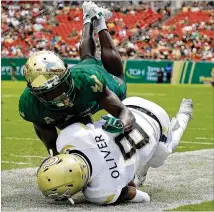  ?? MIKE EHRMANN / GETTY IMAGES ?? Georgia Tech quarterbac­k Tobias Oliver is tackled by South Florida’s Ronnie Hoggins on Saturday in Tampa. Oliver ran for 97 yards and three TDs on 18 carries.