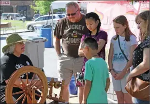  ?? The Sentinel-Record/Rebekah Hedges ?? BASKET WEAVING: Mark, Emily, Marianne, Sylvie and Levi Berry listen as Donna Dunnahoe, left, shows them how to basket weave with recycled materials during Arts & The Park in Hill Wheatley Plaza on Saturday.