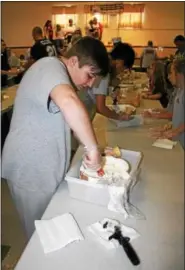  ??  ?? Dawson Haas-Whalen dips and ice cream cone during the Dairy Day celebratio­n at St. Francis Academy in Bally.