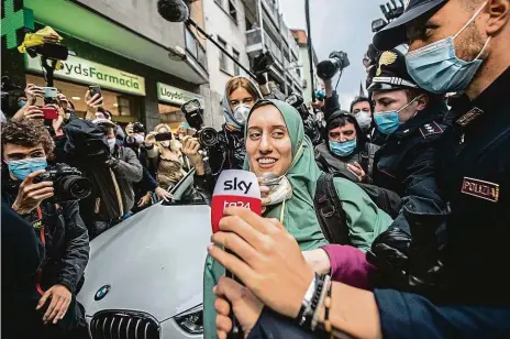  ?? FOTO ČTK/AP ?? Jako celebrita.
Unesenou Italku Silvii Romanovou přivítaly v Miláně média, davy lidí i kostelní zvony. Kolem jejího propuštění ale panuje mnoho nejasností.