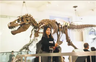  ?? Hiroko Masuike / New York Times ?? A visitor to the Museum of Natural History in New York uses a camera extender, or selfie stick.