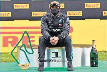  ??  ?? Hamilton posa en el podio del GP de Estiria junto al trofeo del ganador de la carrera.