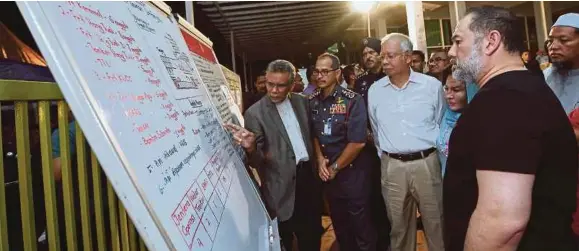  ?? [FOTO BERNAMA] ?? Sultan Muhammad V bersama Najib dan isteri, Datin Seri Rosmah Mansor mendengar taklimat ketika melawat lokasi tragedi kebakaran Pusat Tahfiz
Darul
Quran Ittifaqiya­h, malam tadi.