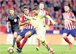  ??  ?? MESSI (tengah) diasak hebat oleh pemain pertahanan Atletico ketika beraksi pada perlawanan liga di Stadium Wanda Metropolit­ano, Madrid Sabtu lepas. — Gambar AFP