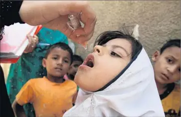  ?? Fareed Khan Associated Press ?? A GIRL is vaccinated in Karachi in April. A security crackdown on militants has helped drive polio numbers back down. Health officials are working to keep them from resurging in the heat of summer.