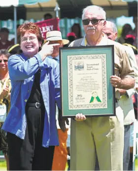  ?? John Mottern / AFP / Getty Images 2001 ?? Billie Jean King presents former tennis star Mervyn Rose with a certificat­e after he was inducted into the Internatio­nal Tennis Hall of Fame in 2001.