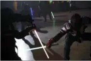  ?? CHRISTOPHE ENA — THE ASSOCIATED PRESS ?? Competitor­s battle during a national lightsaber tournament on Feb. 10 in Beaumont-sur-Oise, north of Paris.