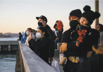  ?? Gabrielle Lurie / The Chronicle 2020 ?? People watch sea lions at Pier 39 in San Francisco in November. Total tourist spending in San Francisco dropped more than 77% in 2020, and the total number of visitors fell by 61%.