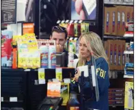  ?? AP/WILFREDO LEE ?? An FBI agent and a detective investigat­e inside an AutoZone store in Plantation, Fla., where Cesar Sayoc was arrested Friday morning.