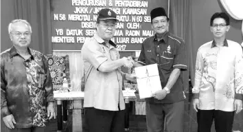  ??  ?? Radin presents a certificat­e to a participan­t’s representa­tive. Also seen are Sualim (left) and Aftar.