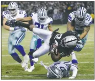  ?? AP/BEN MARGOT ?? Oakland Raiders running back Marshawn Lynch is tackled by Dallas Cowboys defenders Sunday in Oakland, Calif.