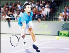  ??  ?? Novak Djokovic of Serbia, chases the ball hit by Tomas Berdych of the Czech Republic, at the Miami Open tennis tournament in Key Biscayne, Florida, March30.