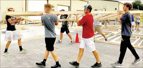  ?? SHELLEY WILLIAMS SPECIAL TO ENTERPRISE-LEADER ?? Matt Jones, left, Jacob Watson, Chase Wade and Braden Risner, youth with Prairie Grove Christian Church, help to build walls for a family who lost their home during the April floods.