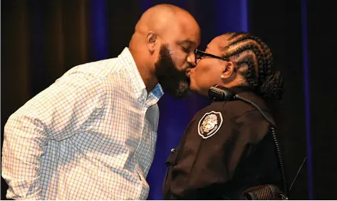  ?? (Pine Bluff Commercial/I.C. Murrell) ?? Newly promoted Pine Bluff Police Sgt. Helen Irby receives a kiss from her husband Brandon after receiving her sergeant's pin during a promotion ceremony Thursday at the Pine Bluff Convention Center.