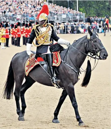  ??  ?? Major Twumasi-ankrah at the Trooping of the Colour, and left, pictured off duty on a visit to Royal Ascot in 2015