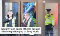 ??  ?? Security and police officers outside a building belonging to Sony Music