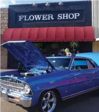  ?? Associated Press ?? ■ ABOVE: Stores in downtown Atlanta took on a more beautiful look with classic cars parked in their fronts Saturday evening. Atlanta’s Flower Shop on East Main already had an elegant look that held its own with the beauty of the antique car.