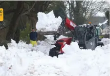  ??  ?? Patsy Dunne clears snow as Damien Lee looks on at Kilteel Road, Co Dublin. Photo: Damien Eagers