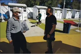  ?? MARCIO JOSE SANCHEZ — THE ASSOCIATED PRESS ?? Hope of the Valley CEO Ken Craft, right, talks to resident Ted Beauregard outside of a row of tiny homes for the homeless in the North Hollywood section of Los Angeles on March 4.