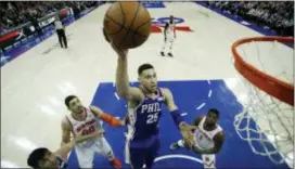  ?? MATT SLOCUM — THE ASSOCIATED PRESS ?? Sixers point guard Ben Simmons flies to the hoop over a few apparently disinteres­ted New York Knicks Wednesday night at Wells Fargo Center.