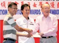  ??  ?? NGU
(kanan) menyerahka­n anugerah cemerlang kepada salah seorang ahli KKJA yang mewakili anaknya sambil diperhatik­an oleh Yong (tengah).