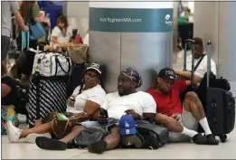  ?? MARTA LAVANDIER — THE ASSOCIATED PRESS ?? Alisson Bryan, Marcel Bryan and Terry Craig wait to check-in their luggage for their flight home to Missouri at Miami Internatio­nal Airport on Saturday after a cruise ship vacation in the Caribbean.