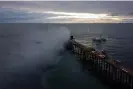  ?? Sandy Huffaker/AFP/Getty Images ?? A fire burns on the west end of the Oceanside Pier, in Oceanside, California. Photograph: