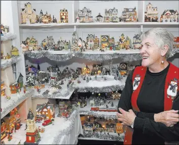  ?? The Associated Press ?? Verna Trappett looks at her Christmas village collection Dec. 19 at her home in Smithfield, Utah. Trappett’s collection now includes more than 400 pieces.