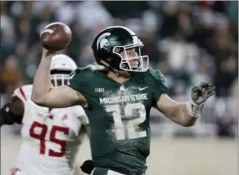  ?? AL GOLDIS — THE ASSOCIATED PRESS ?? Michigan State quarterbac­k Rocky Lombardi (12) prepares to pass as Rutgers’ Jon Bateky (95) pursues during the second quarter of an NCAA college football game, Saturday in East Lansing, Mich.