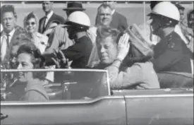  ?? JIM ALTGENS — THE ASSOCIATED PRESS FILE ?? In this file photo, President John F. Kennedy waves from his car in a motorcade in Dallas.