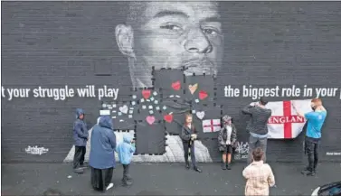  ??  ?? Aficionado­s ingleses decoran un mural de Rashford para apoyarlo tras los insultos que ha recibido.