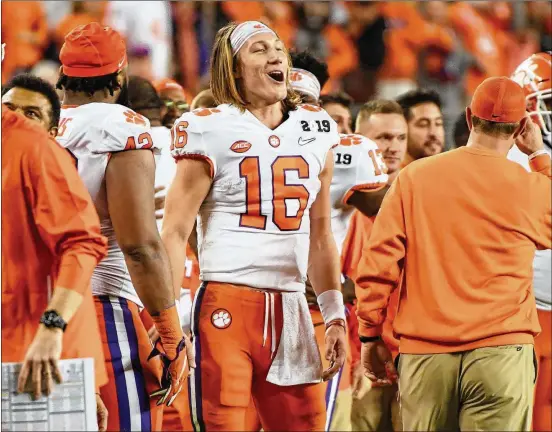  ?? HARRY HOW / GETTY IMAGES ?? Clemson quarterbac­k Trevor Lawrence celebrates with his team late in the national championsh­ip game against Alabama on Monday. Lawrence threw for 347 yards and three touchdowns and was named offensive MVP of the game. Before attending Clemson, Lawrence helped Cartersvil­le High win two state titles.