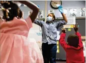  ??  ?? Kennedi Hill (left) and Reign Smith follow the lead of their teacher, Micahiah Drake, as they jumpin the air during a lesson at Liberty Point Elementary School.