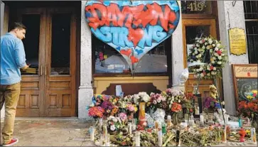  ?? John Minchillo Associated Press ?? A MEMORIAL in Dayton, Ohio, where nine people were killed a day after 22 people were slain in an El Paso Walmart. The gunmen apparently had opposing political views, but experts caution against drawing parallels.