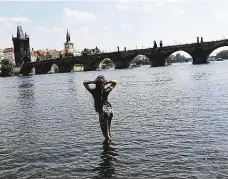  ?? Foto: Dan Materna, MAFRA ?? Včerejší Praha Před výhní na Karlově mostě chránila turisty voda ve Vltavě. Dlouhá série veder však dnes skončí.