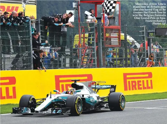  ??  ?? Mercedes driver Lewis Hamilton of Britain gets the checkered flag as he crosses the finish line to win the Belgian Formula One Grand Prix in SpaFrancor­champs Photo: AP