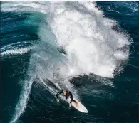  ??  ?? A surfer rides a wave between the beachside suburbs of Clovelly and Coogee in Sydney, Australia