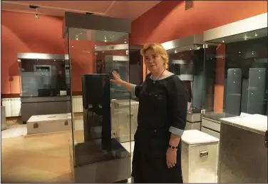  ?? (AP/Efrem Lukatsky) ?? Natalia Panchenko, director of the Museum of Historical Treasures of Ukraine, shows empty showcases last month in Kyiv, Ukraine. Fearing Russian troops would storm the city, Panchenko dismantled exhibits, carefully packing away artifacts into boxes for evacuation.