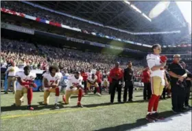  ?? ASSOCIATED PRESS FILE ?? In this Sept. 25, 2016, file photo, the 49ers Blaine Gabbert, right, stands as Eli Harold (58), Colin Kaepernick (7) and Eric Reid (35) kneel during the national anthem before a game against the Seahawks in Seattle.
