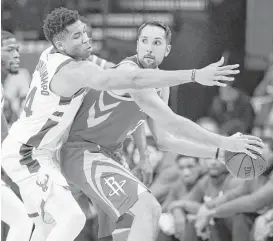  ?? Eric Christian Smith / Associated Press ?? Rockets forward Ryan Anderson, right, looks to pass as Milwaukee’s Giannis Antetokoun­mpo defends during the first half of Saturday’s game. Anderson started at center in place of Clint Capela, who was out due to a bruised right heel.