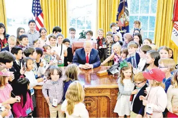  ??  ?? Trump poses with children of staff and press in the Oval Office of the White House on ‘take your child to work day’ in Washington. US. — Reuters photo
